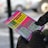 A person wearing black gloves is holding a colorful lottery scratch-off ticket. The ticket includes information about a $1,000,000 guaranteed minimum payout and features multiple games with various prize amounts.